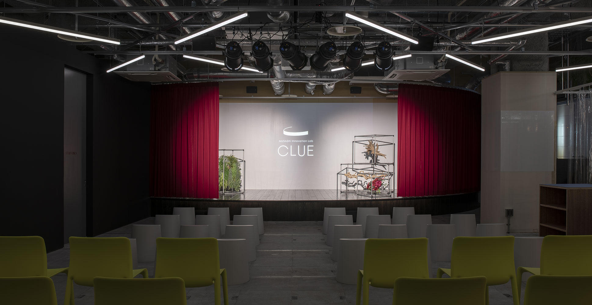 MUSASHi Innovation Lab CLUEのステージ。赤い幕の前に客席が並ぶ